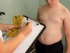 Anak laki-laki kelebihan berat badan berkonsultasi dengan dokter / iStockphoto